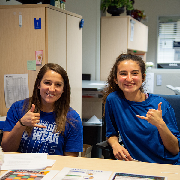 Women holding up shakas wearing bluesday shirts